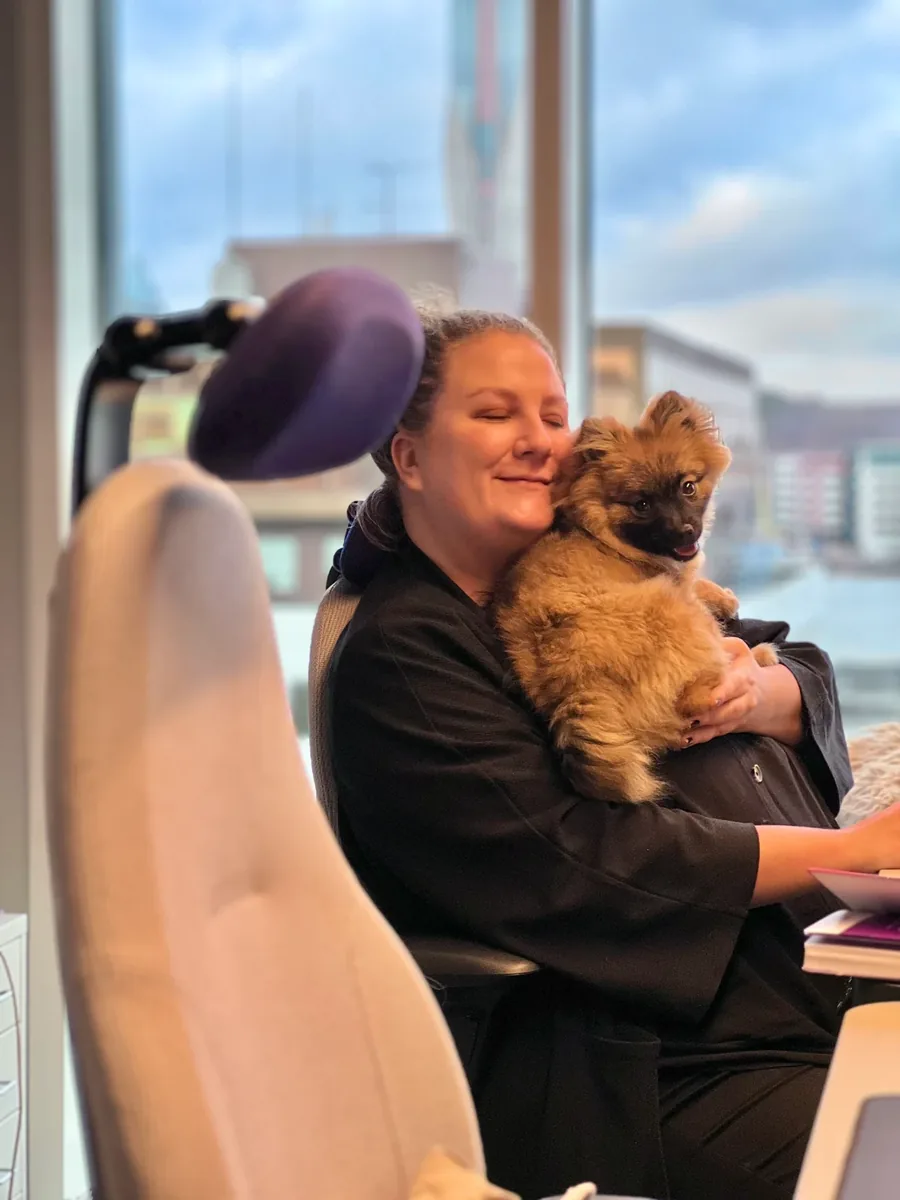An Adway team member with an office dog at her desk